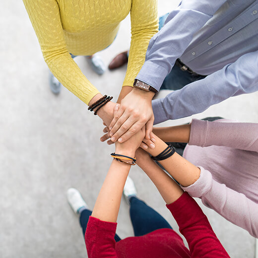 a group of people with there hands in the middle