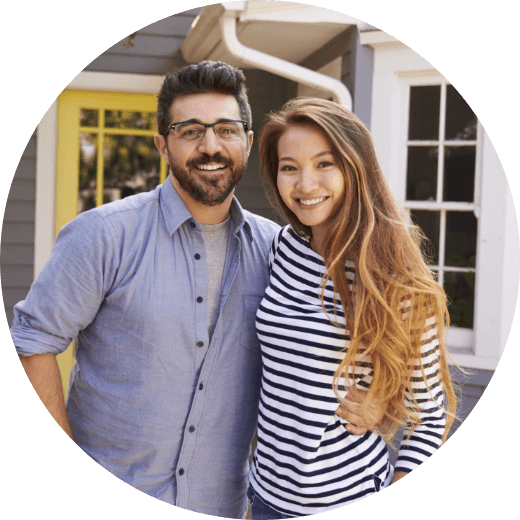 a man and woman in front of their home