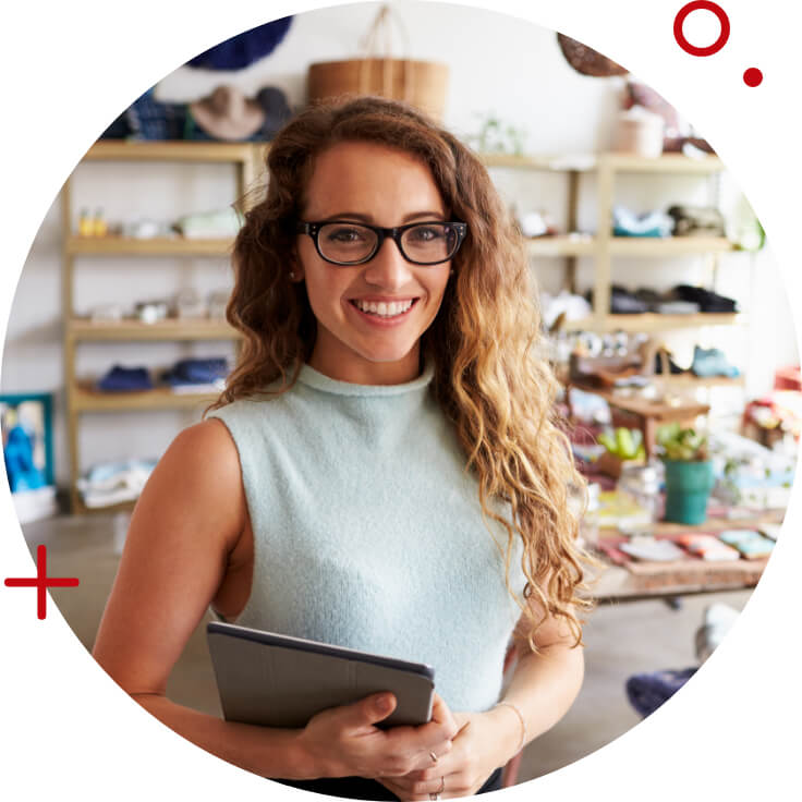 a young professional looking woman smiling with her products behind her