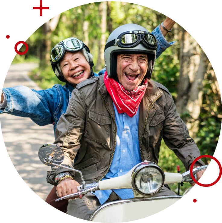 two elderly people riding a moped and smiling