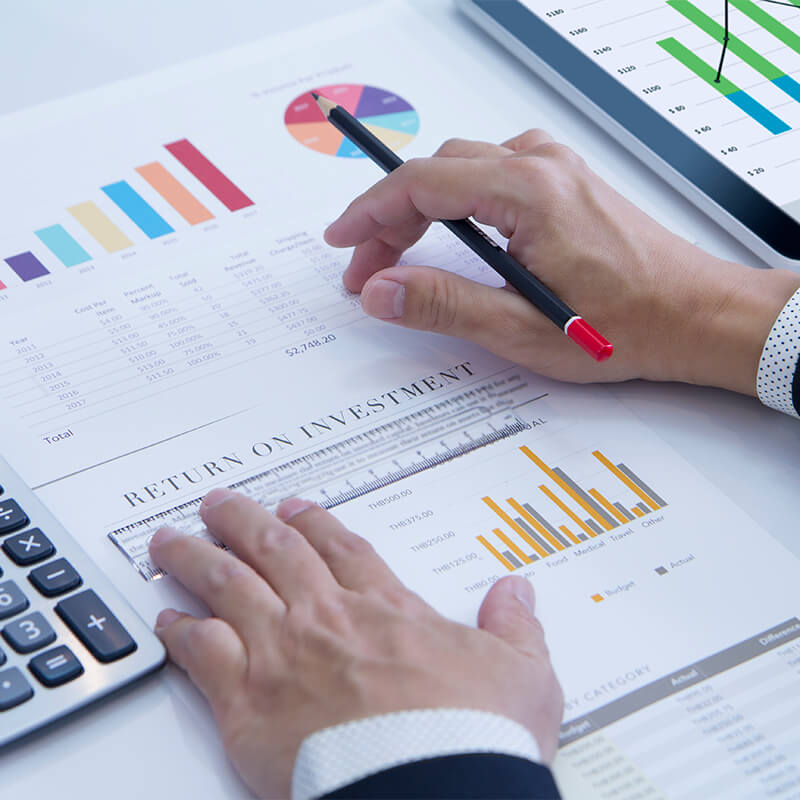 Close-up of an ROI analysis with colorful graphs and a calculator, signifying strategic investment planning for mymncu.org visitors.